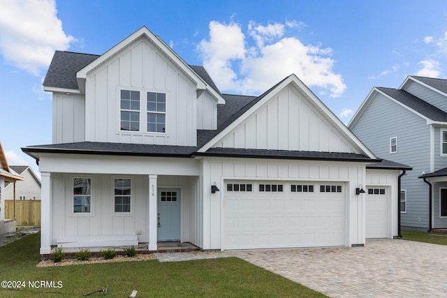 view of front of home featuring a garage, a porch, and a front lawn