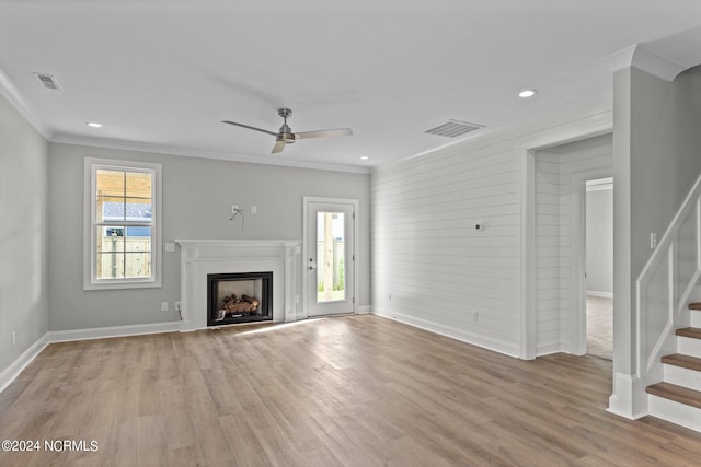 unfurnished living room with ceiling fan, crown molding, and light wood-type flooring