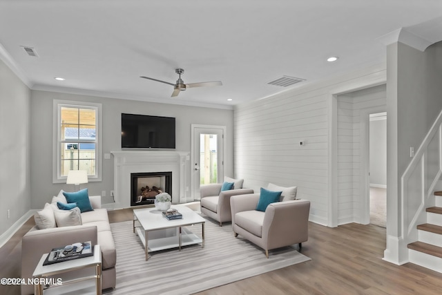 living room featuring crown molding, hardwood / wood-style flooring, and ceiling fan