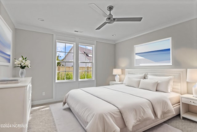 carpeted bedroom featuring ceiling fan and crown molding