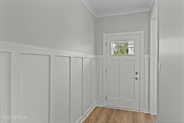 doorway with ornamental molding and light wood-type flooring