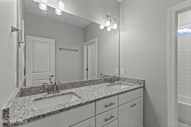 bathroom with large vanity,  shower combination, and double sink