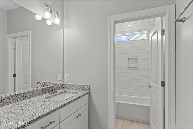 bathroom with hardwood / wood-style flooring, bathtub / shower combination, and vanity