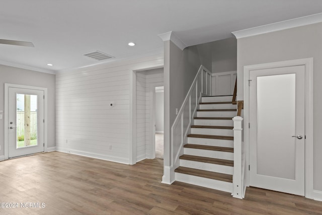 stairway featuring ornamental molding and hardwood / wood-style flooring