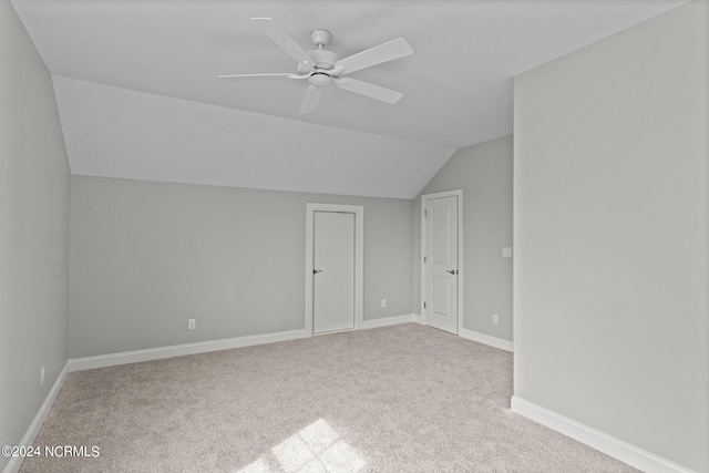 additional living space featuring light colored carpet, ceiling fan, and lofted ceiling