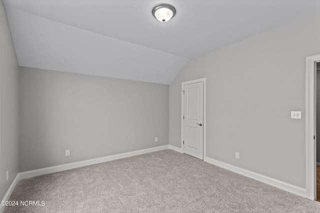 additional living space featuring vaulted ceiling and carpet floors