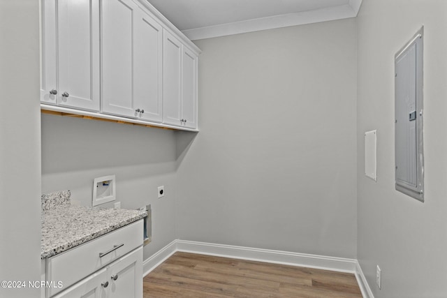 laundry area featuring dark hardwood / wood-style floors, hookup for a washing machine, electric dryer hookup, ornamental molding, and cabinets