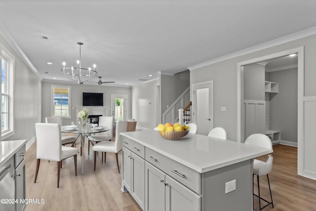 kitchen featuring a center island, light hardwood / wood-style floors, crown molding, and decorative light fixtures