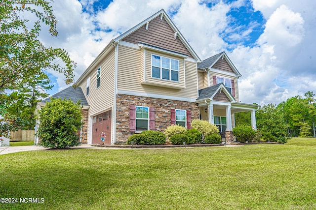 craftsman inspired home with a garage, a front lawn, and covered porch