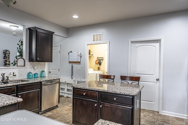 kitchen featuring dark brown cabinets, sink, backsplash, separate washer and dryer, and stainless steel dishwasher