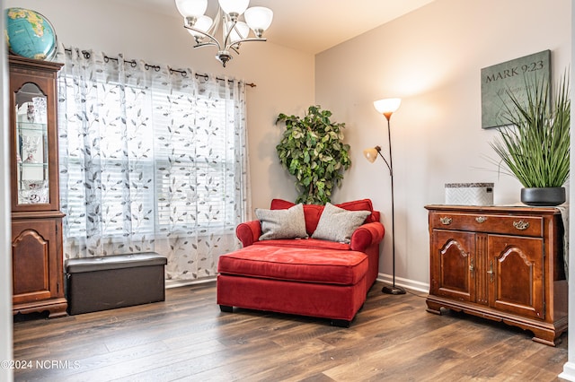 sitting room with an inviting chandelier, a healthy amount of sunlight, and dark hardwood / wood-style floors