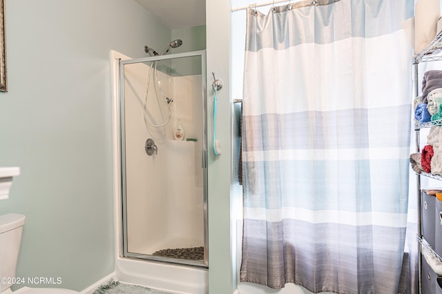 bathroom with a shower with door and toilet