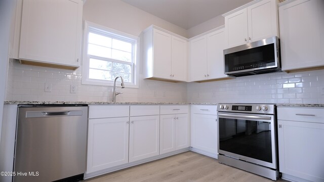 1254 Opaca Dr SE, Bolivia, NC 28422 - kitchen featuring appliances with stainless steel finishes, a sink, white cabinets, and backsplash