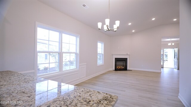 1254 Opaca Dr SE, Bolivia, NC 28422 - unfurnished living room with a glass covered fireplace, recessed lighting, light wood-style flooring, plenty of natural light, and lofted ceiling