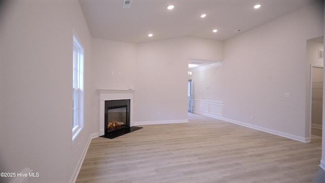 1254 Opaca Dr SE, Bolivia, NC 28422 - unfurnished living room with a glass covered fireplace, recessed lighting, light wood-type flooring, plenty of natural light, and lofted ceiling
