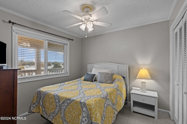 carpeted bedroom featuring a closet, a textured ceiling, crown molding, and ceiling fan