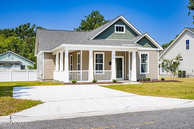 view of front facade featuring covered porch, central AC unit, and a front yard