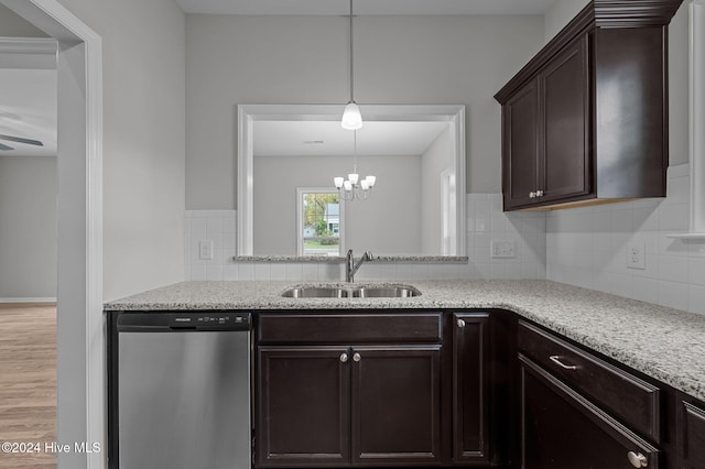 kitchen with tasteful backsplash, light wood-type flooring, hanging light fixtures, sink, and dishwasher