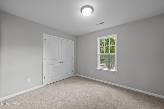 unfurnished bedroom with a closet and carpet