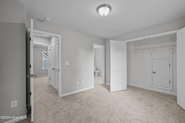 unfurnished bedroom with a closet and light carpet