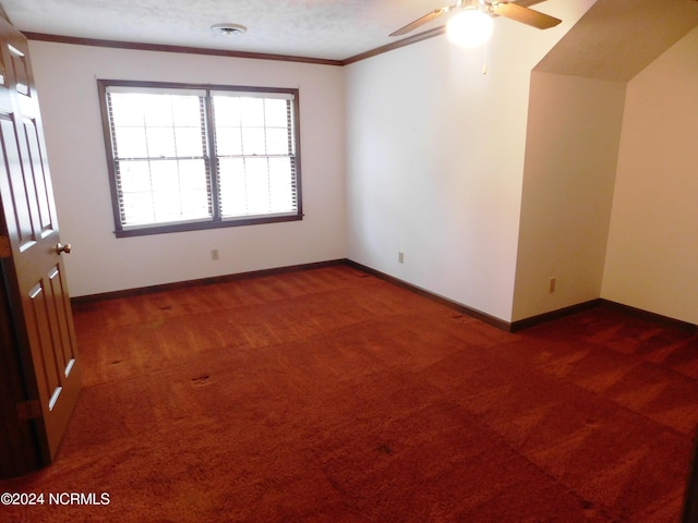 spare room with ceiling fan, crown molding, and dark carpet