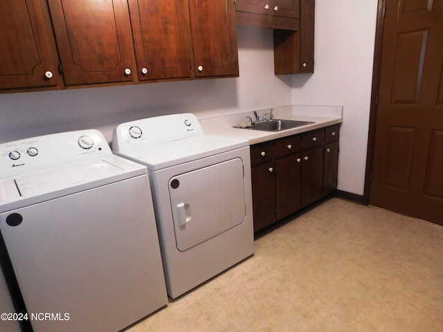 washroom with washer and clothes dryer, cabinets, sink, and light tile flooring