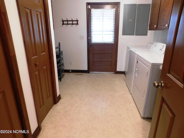 clothes washing area featuring washing machine and dryer, cabinets, and light carpet