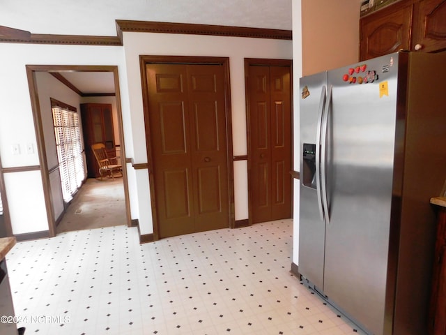 kitchen featuring stainless steel fridge, light tile flooring, and ornamental molding