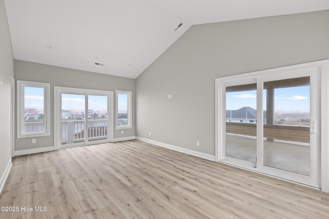 unfurnished room featuring baseboards, high vaulted ceiling, visible vents, and light wood-style floors