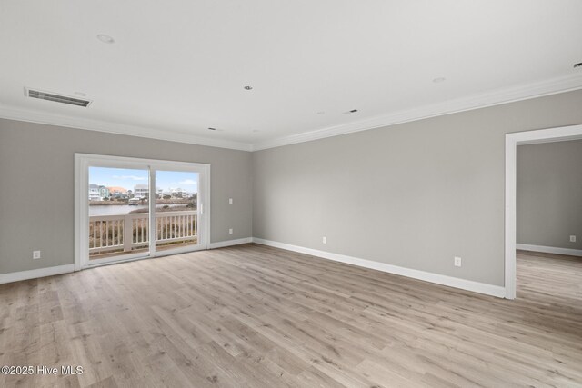 unfurnished room featuring light wood finished floors, visible vents, a water view, ornamental molding, and baseboards