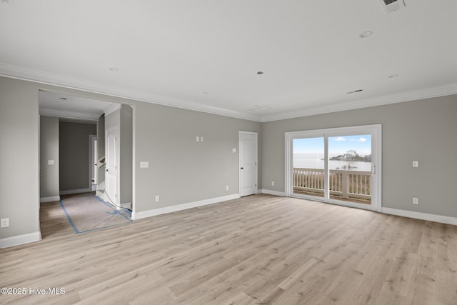 spare room featuring ornamental molding, baseboards, and light wood finished floors