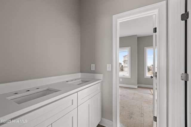 bathroom with a sink and baseboards