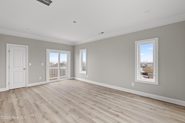 spare room with baseboards, visible vents, ornamental molding, and light wood-style flooring