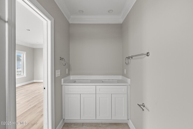 bathroom featuring ornamental molding, wood finished floors, and baseboards