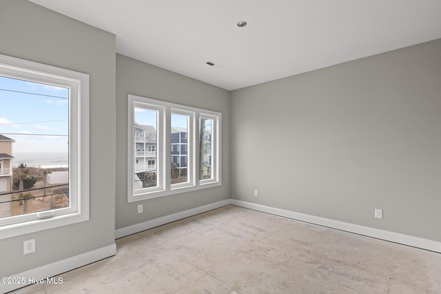 empty room with baseboards, visible vents, and a healthy amount of sunlight