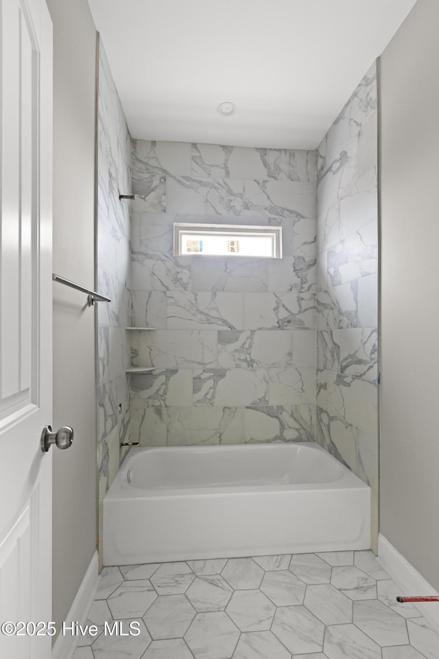 bathroom with shower / bath combination and baseboards