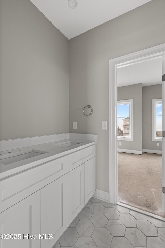 bathroom featuring baseboards and a sink