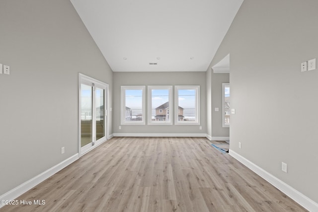 interior space with high vaulted ceiling, light wood-style flooring, and baseboards