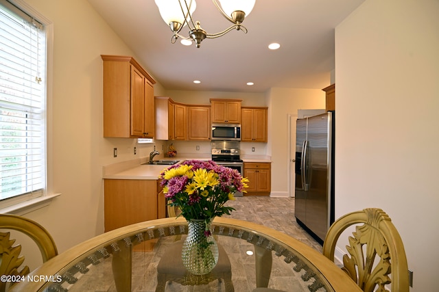 kitchen featuring hanging light fixtures, appliances with stainless steel finishes, sink, and a chandelier