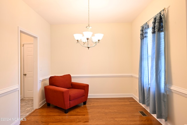 living area with an inviting chandelier and hardwood / wood-style flooring