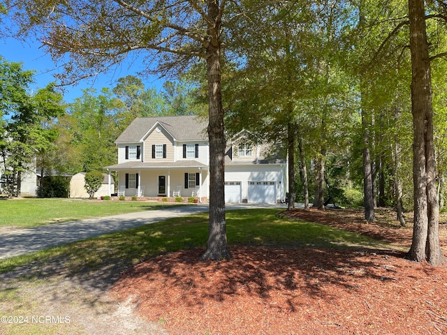 view of front of house with a garage, a porch, and a front lawn