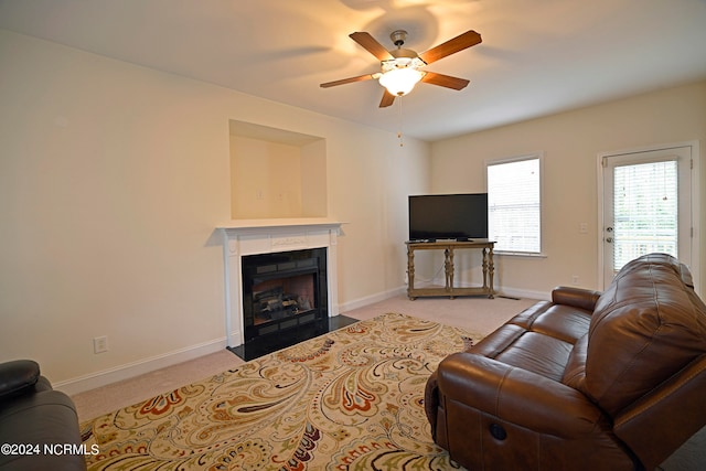 carpeted living room with ceiling fan