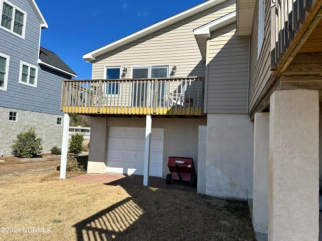 rear view of property featuring a balcony and a garage