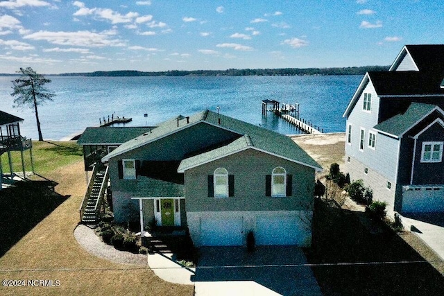 view of front of home with a water view and a dock