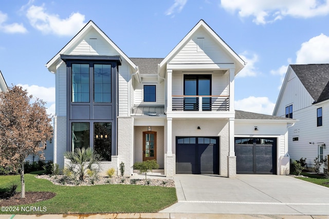 view of front facade featuring a balcony, a front yard, and a garage