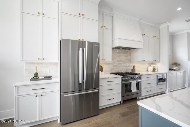 kitchen with white cabinetry, custom range hood, dark hardwood / wood-style floors, and appliances with stainless steel finishes