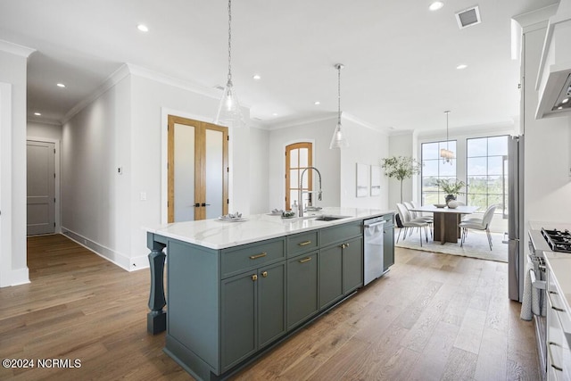 kitchen with sink, a center island with sink, wood-type flooring, and stainless steel appliances