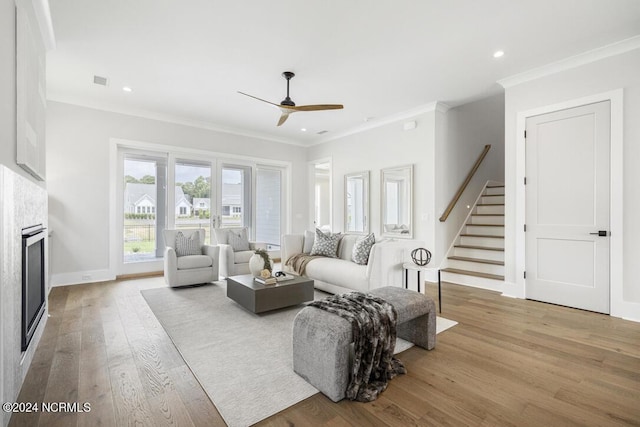 living room featuring ceiling fan, light hardwood / wood-style flooring, and ornamental molding