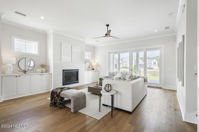 living room featuring hardwood / wood-style flooring, ceiling fan, and ornamental molding