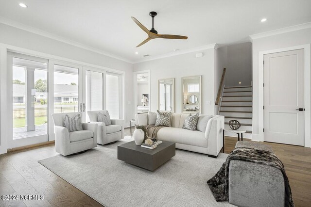 living room featuring crown molding, light hardwood / wood-style flooring, and ceiling fan